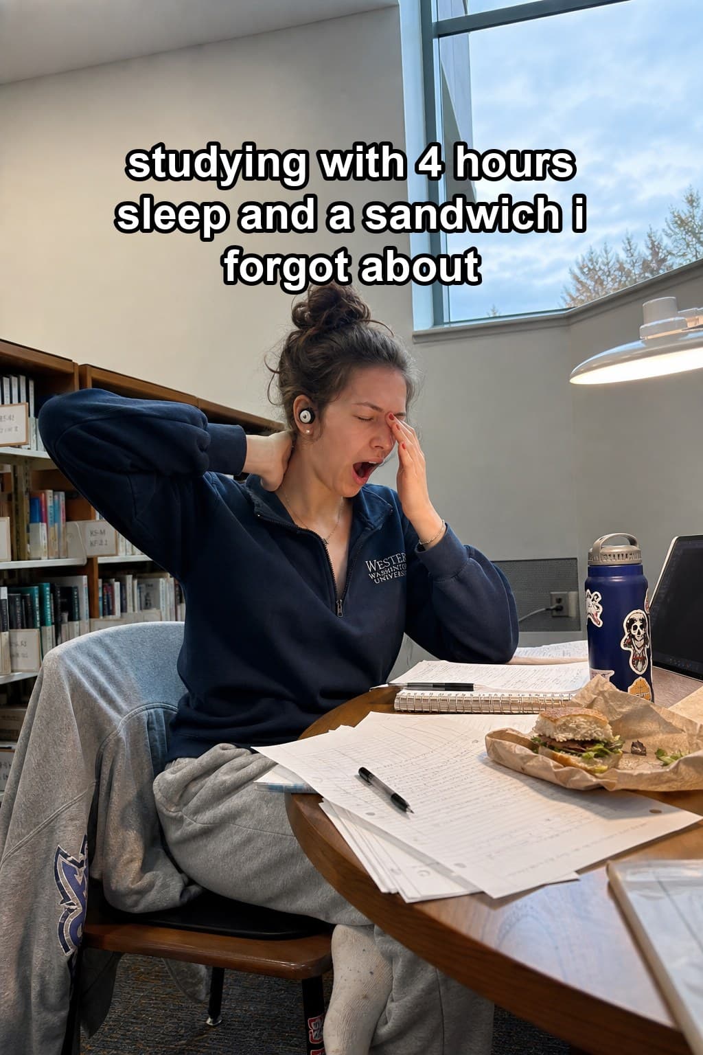 Stratos post: studying at a library table mid-yawn
